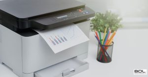 copier on the table with a sheet of paper printed out next to holder full of colour pencils - by BDL Copier Leasing Experts