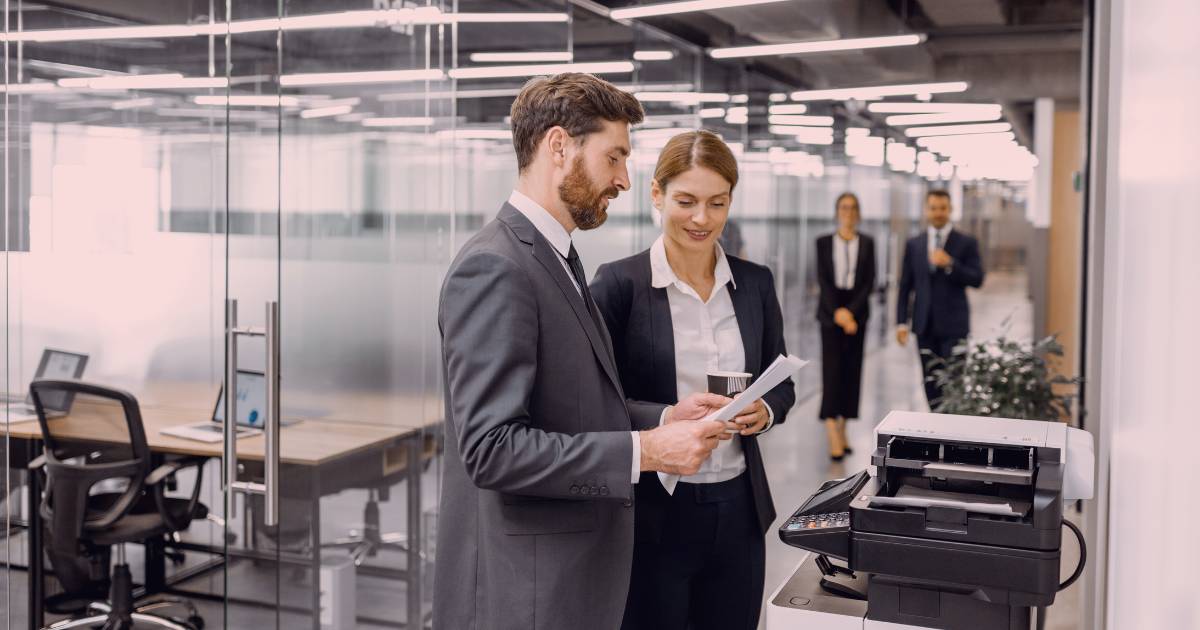 two business professionals looking at the cost of leasing a printer